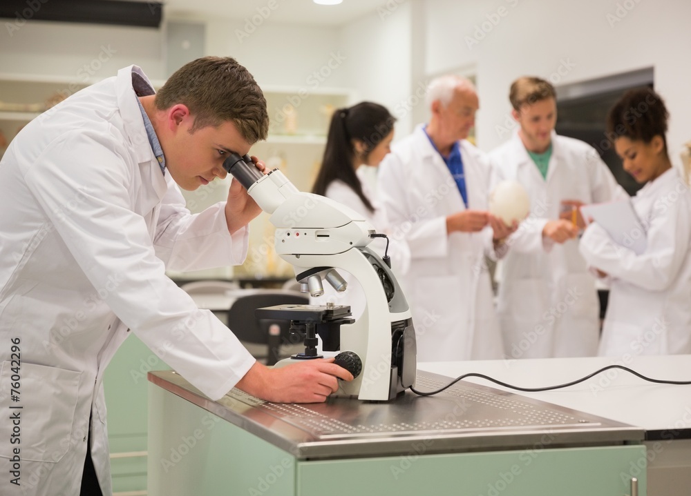 Obraz premium Young medical student working with microscope