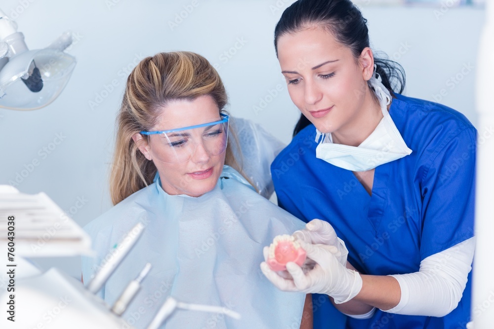 Dentist showing patient model of teeth Stock Photo | Adobe Stock