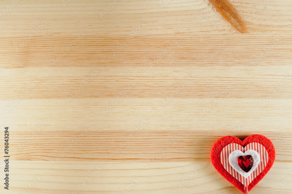 The heart of felt on wooden background The heart of felt on wooden background