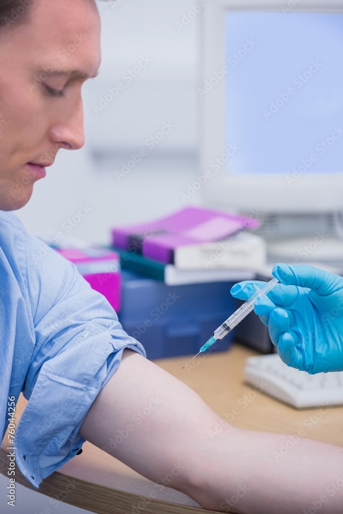 Doctor about doing an injection to the patient arm Doctor about doing an injection to the patient arm