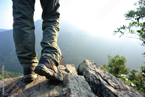  woman hiker stand on mountain peak rock 