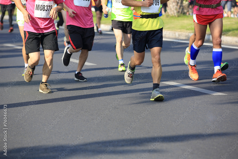 marathon athletes legs running on city road