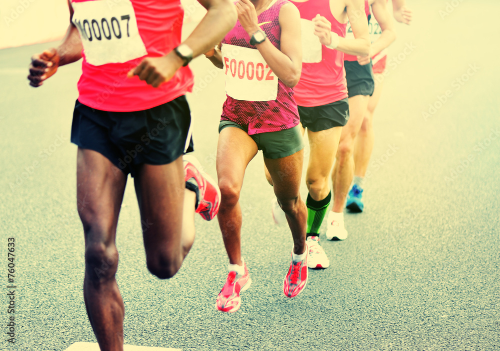 marathon athletes legs running on city road marathon athletes legs running on city road