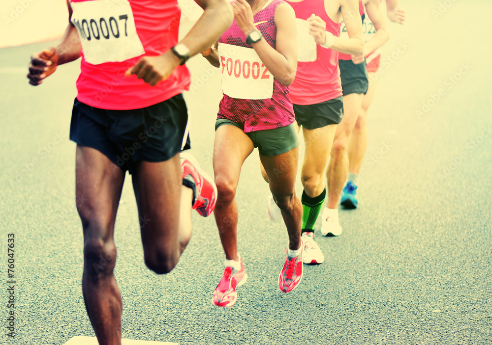 	marathon athletes legs running on city road