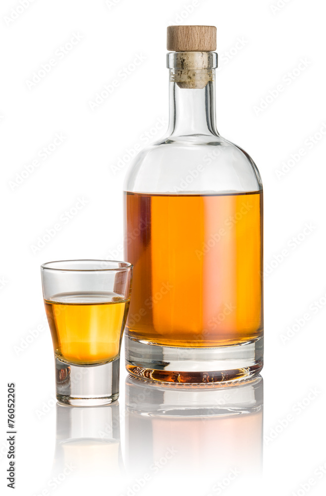 Flasche und Shotglas gefüllt mit bernsteinfarbener Flüssigkeit Flasche und Shotglas gefüllt mit bernsteinfarbener Flüssigkeit