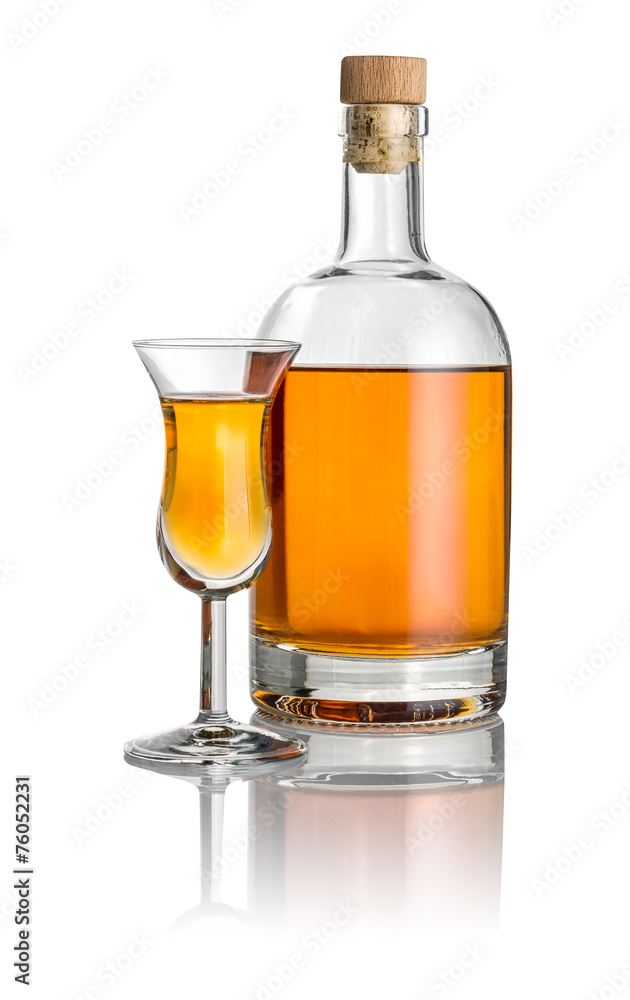 Flasche und hohes Kelchglas mit bernsteinfarbener Flüssigkeit Flasche und hohes Kelchglas mit bernsteinfarbener Flüssigkeit