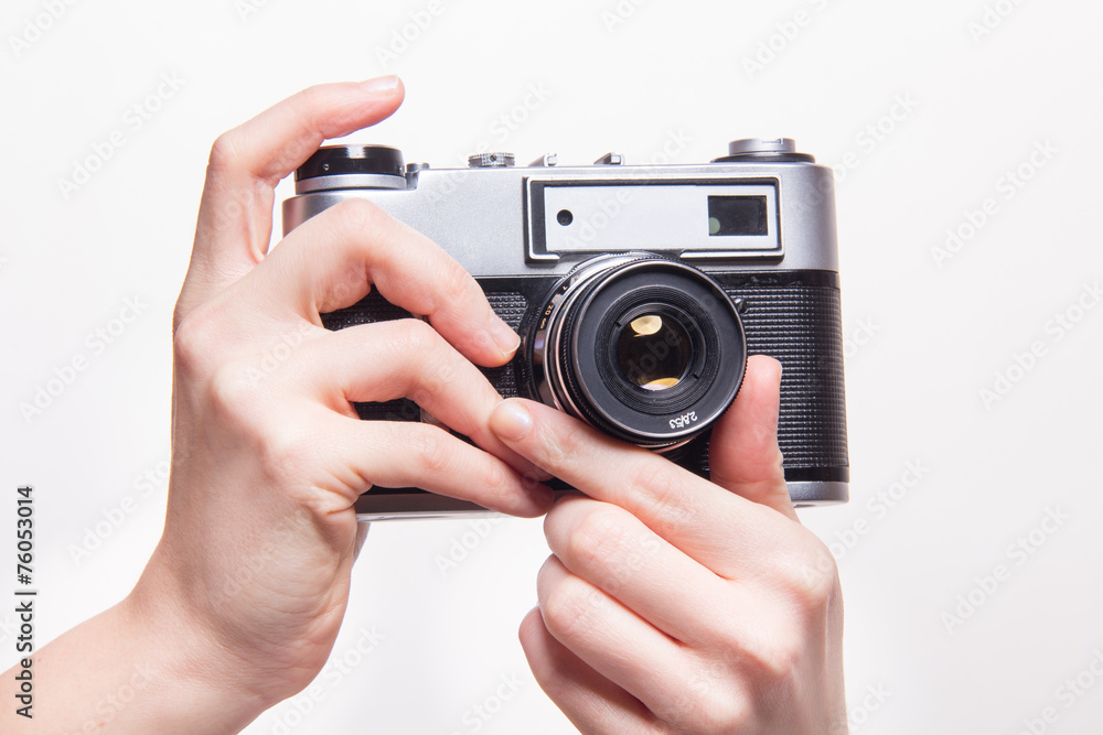 Hands zooming lens in classic 35mm camera Hands zooming lens in classic 35mm camera