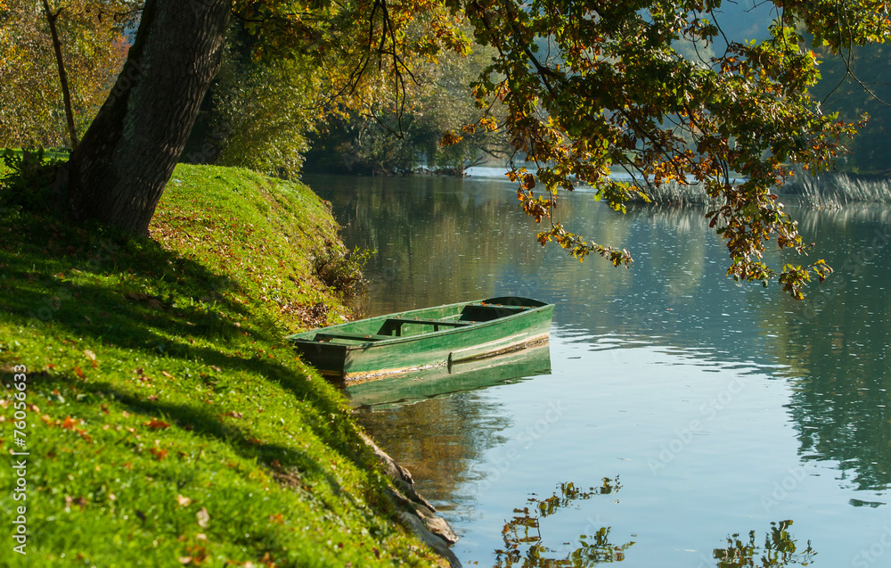 Lonely boat by Krka river, Otocec, Slovenia Lonely boat by Krka river, Otocec, Slovenia