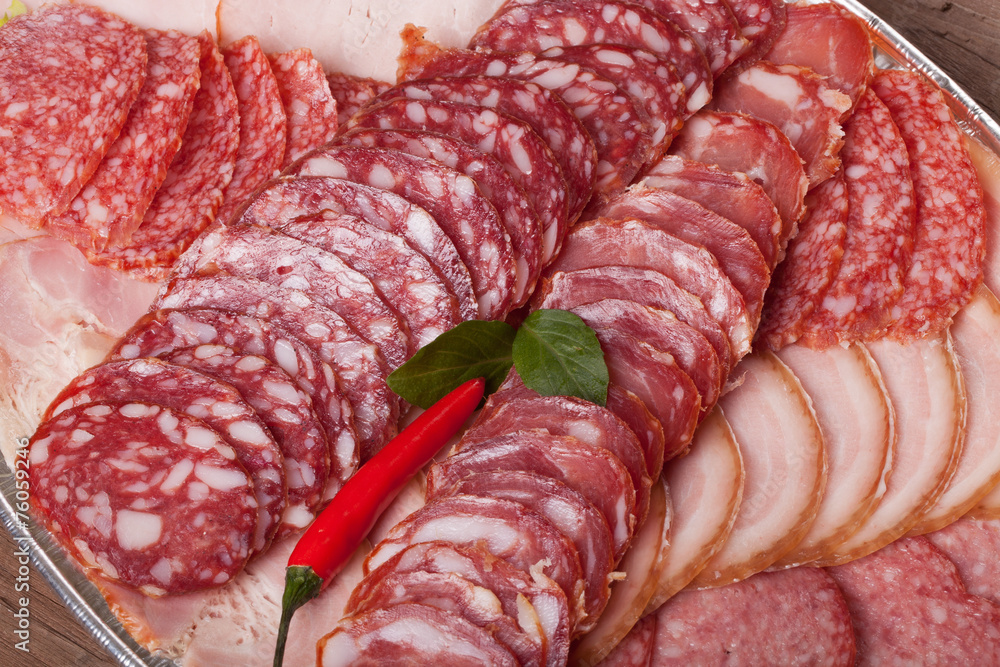 Plate with different kinds of sliced sausage and red hot chilli Plate with different kinds of sliced sausage and red hot chilli