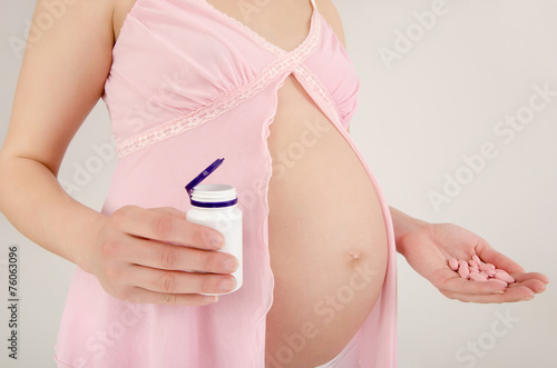 Wallpaper Mural Woman expecting baby holding pills in her hands taking prenatals Torontodigital.ca