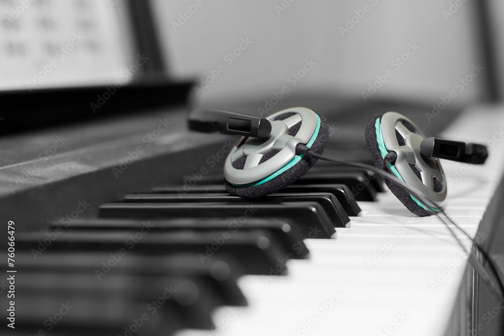 Headphones lying on the piano keys closeup Headphones lying on the piano keys closeup