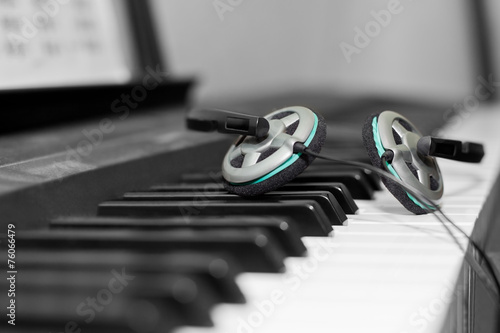 Headphones lying on the piano keys closeup