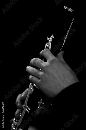 Human hand plays the clarinet closeup in black and white