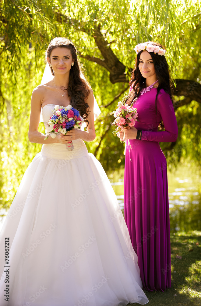 brunette bride posing with bridesmaid in long dress posing at pa