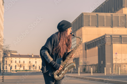 Tableau sur toile Beautiful young woman playing tenor saxophone