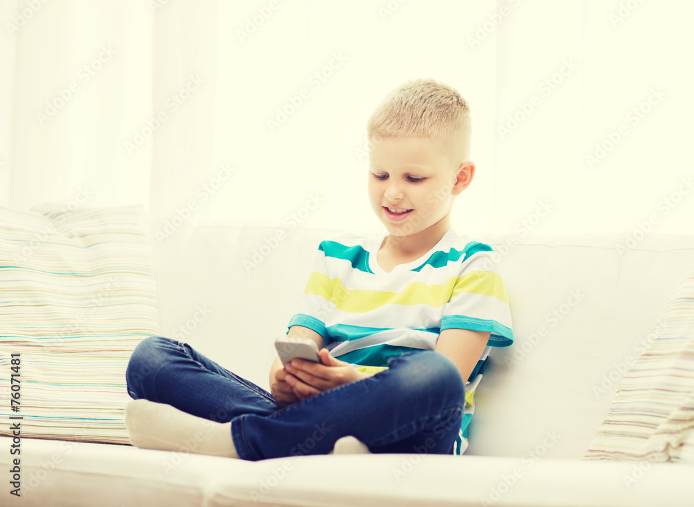 smiling little boy with smartphone at home smiling little boy with smartphone at home