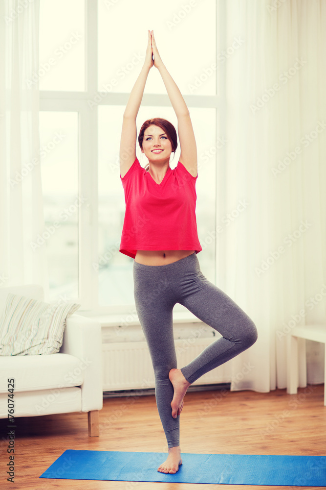 Fototapeta premium smiling redhead teenager meditating at home