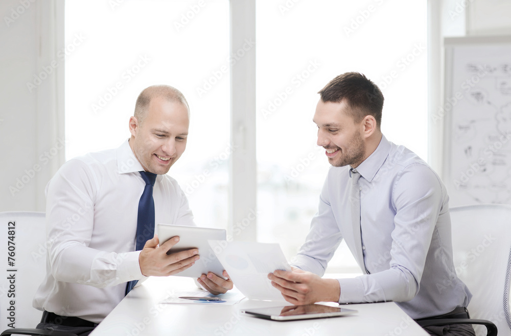 two smiling businessmen with tablet pc in office two smiling businessmen with tablet pc in office