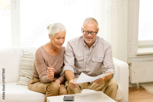 senior couple with papers and calculator at home