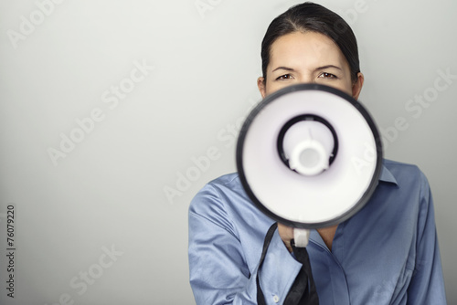 Junge Frau ruft laut mit einem Megafon photo