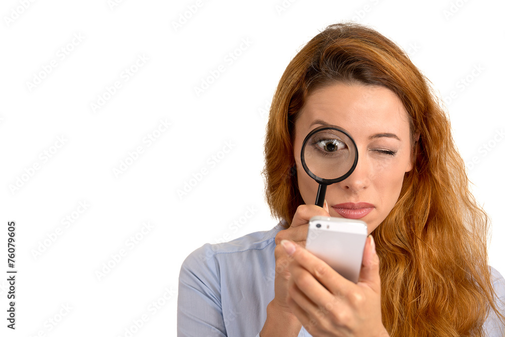 woman looking through magnifying glass at smart phone woman looking through magnifying glass at smart phone