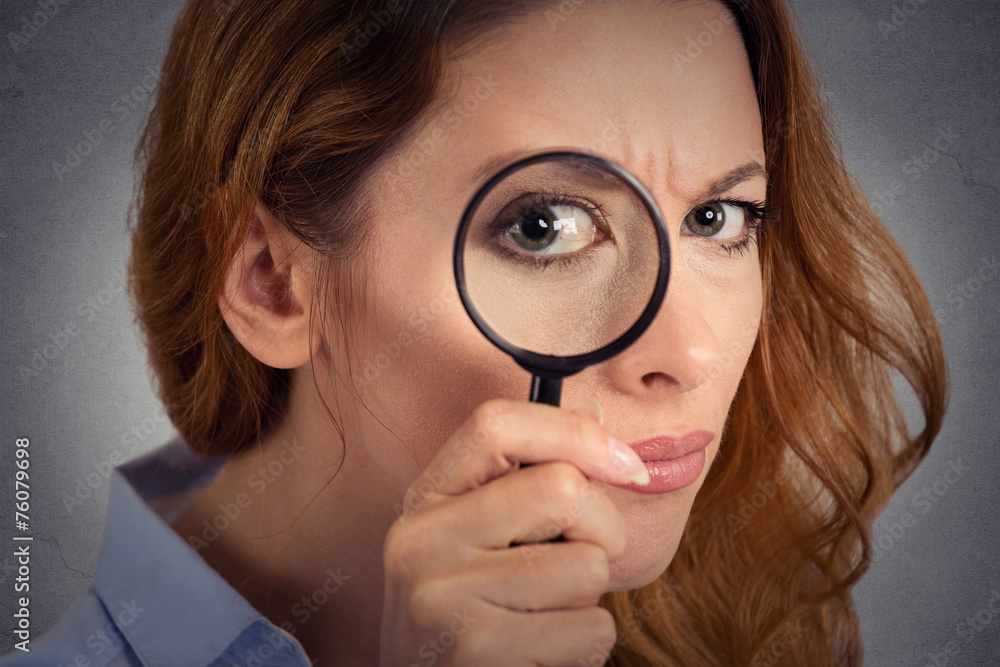 Headshot woman investigator looking through magnifying glass Headshot woman investigator looking through magnifying glass