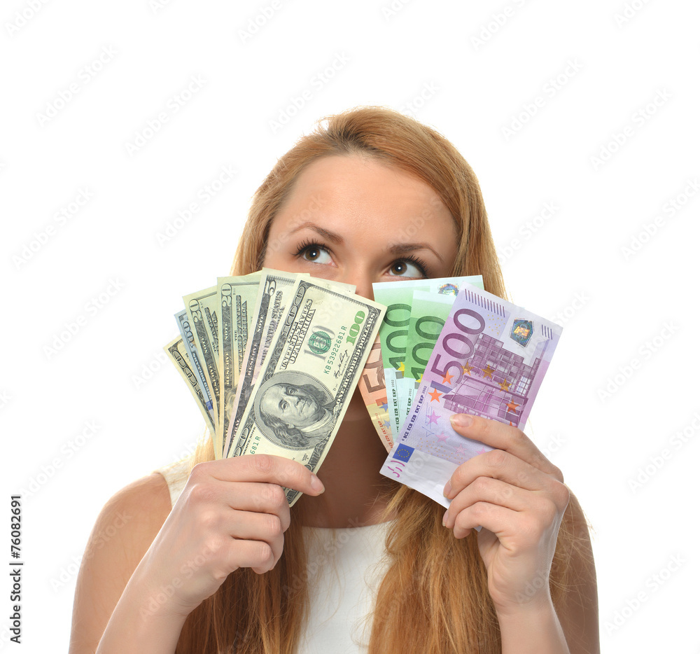 Happy young woman holding up cash money dollars and euros Happy young woman holding up cash money dollars and euros
