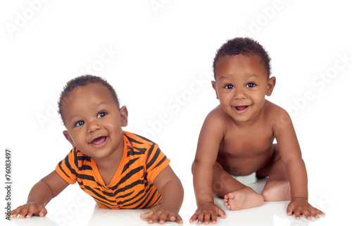 Two small identical black infants on white floor photo