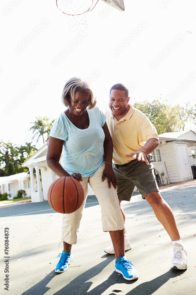 Senior Couple Playing Basketball Together