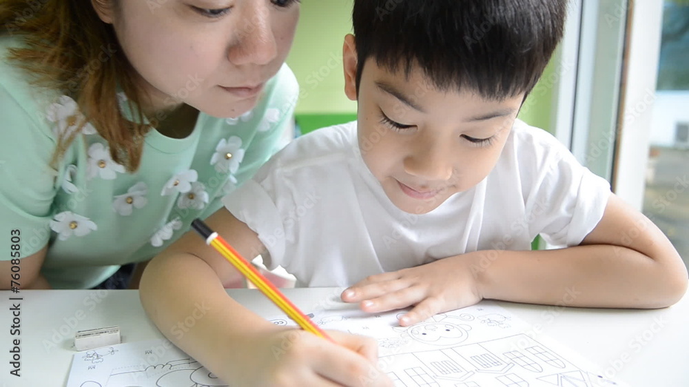 Asian Mom is helping her son to do homework of the school Asian Mom is helping her son to do homework of the school