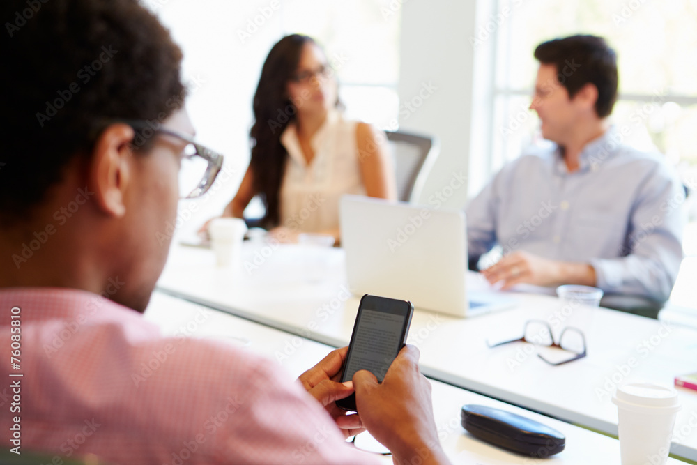 Designer Using Mobile Phone During Meeting Designer Using Mobile Phone During Meeting