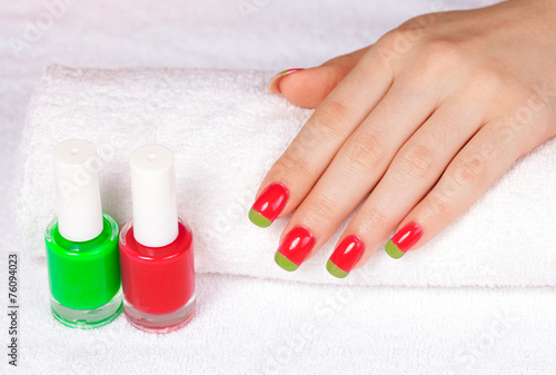 Beautiful female hand with two-color manicure on white towel
