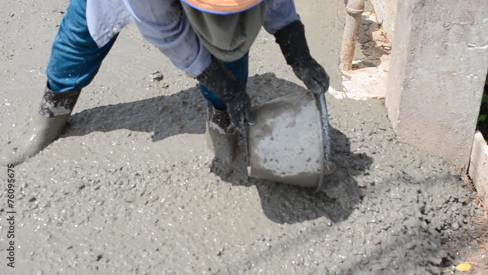 Construction worker finishes pouring concrete floor Construction worker finishes pouring concrete floor