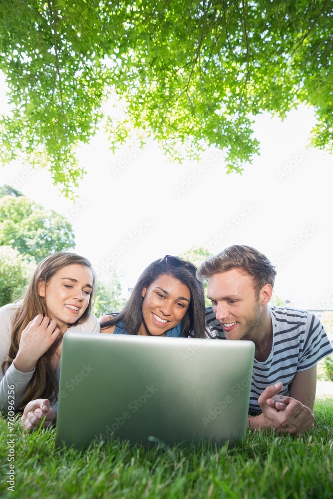 Happy students using laptop outside Happy students using laptop outside