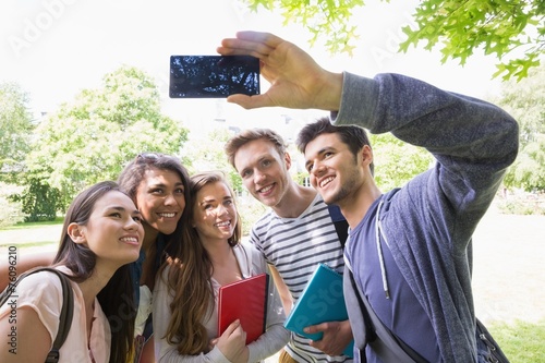Happy students taking a selfie outside on campus