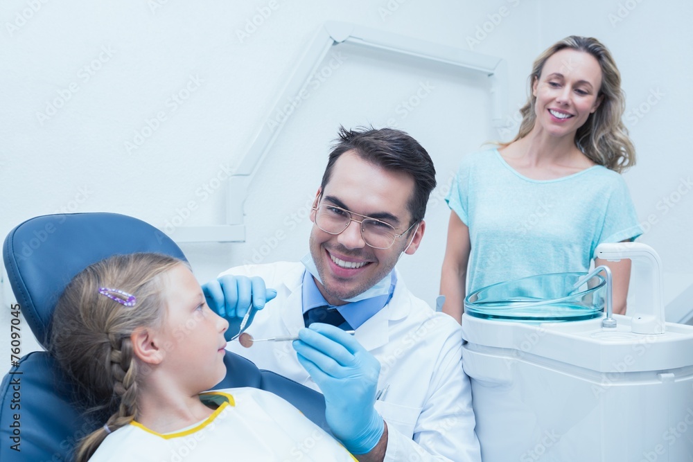 Fototapeta premium Dentist examining girls teeth with assistant