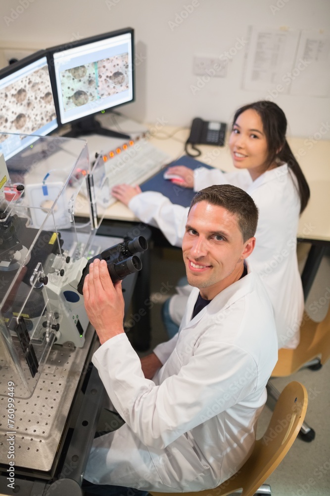 Obraz premium Biochemistry students using large microscope and computer