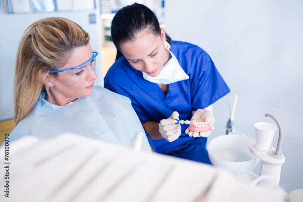 Obraz premium Dentist showing patient model of teeth