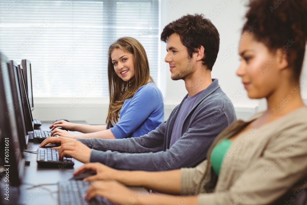 Happy student in computer class smiling at camera Happy student in computer class smiling at camera