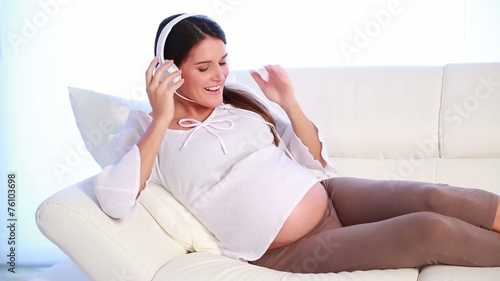 young pregnant woman relaxing with music