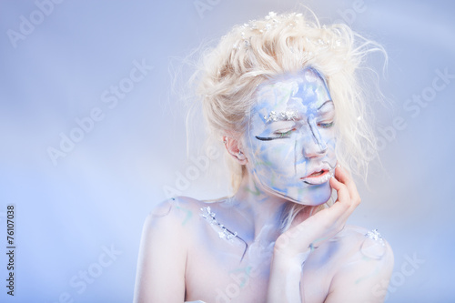 Portrait of woman with unusual bleu paint make-up with flowers
