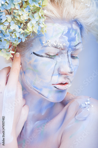 Fototapeta Naklejka Na Ścianę i Meble -  Portrait of woman with unusual bleu paint make-up with flowers