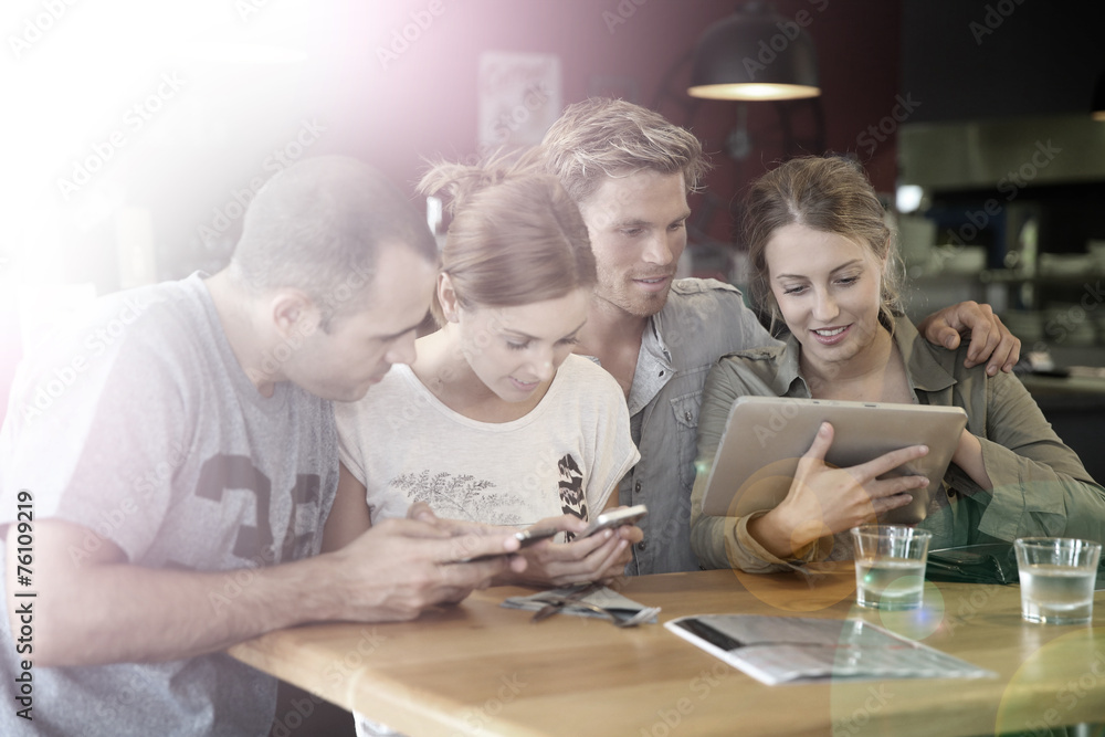 Fototapeta premium Students in campus lounge websurfing on tablet