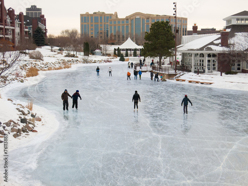 People skate at early evening on a frozen lake