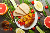 Sausage with potatoes and vegetables on a wooden background