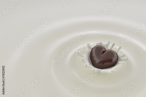 Chocolate heart falls into milk