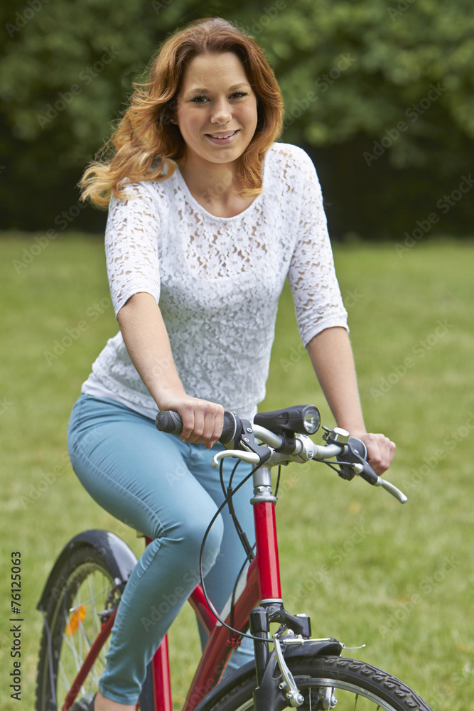 Naklejka premium Portrait Of Teenager Girl Riding Bike In Countryside