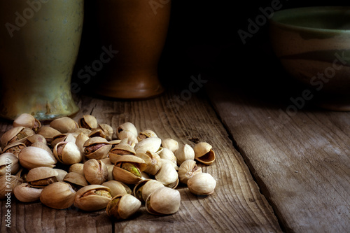 pistachio nuts on dark wood, copy space in the background