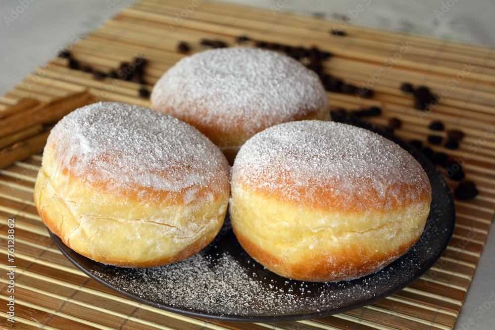 Donuts with powdered sugar on the brown plate Donuts with powdered sugar on the brown plate