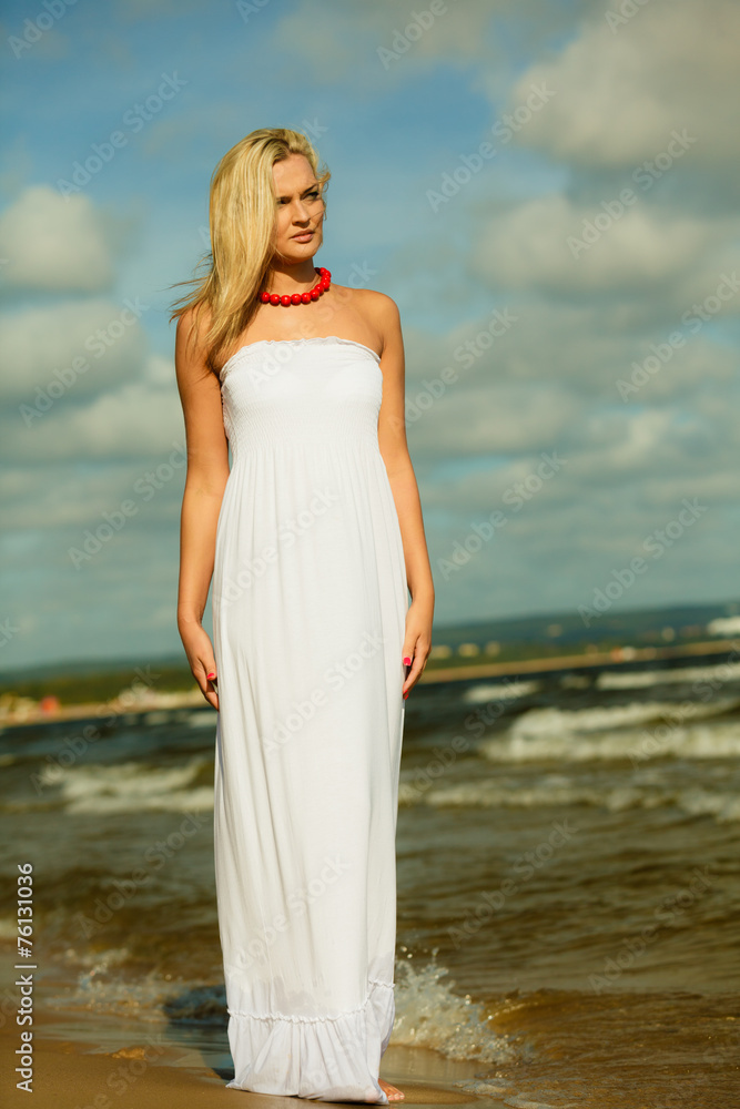 Beautiful blonde girl on beach, summertime